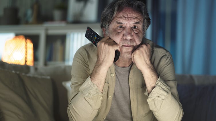 man worried with hands under chin