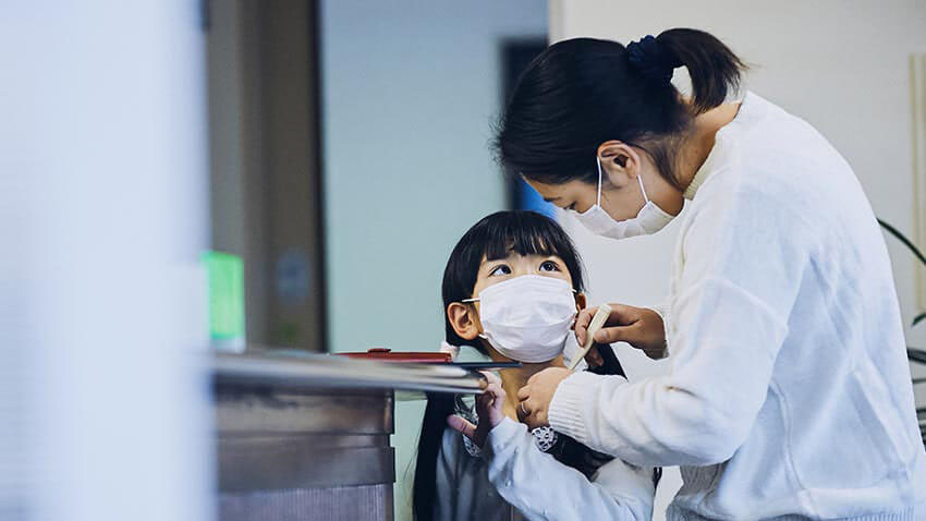 母亲和孩子用面具在医生