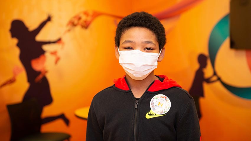 在医院的孩子戴着面具和橙色的背景