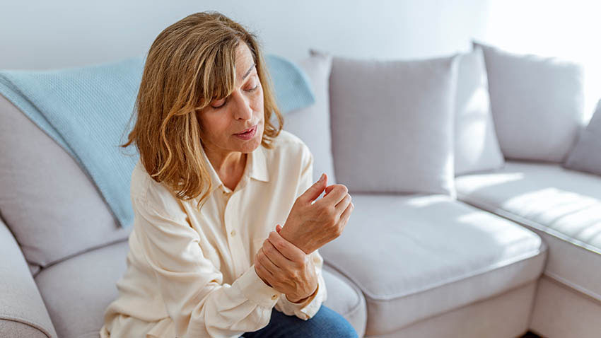 长沙发的妇女用手腕伤害