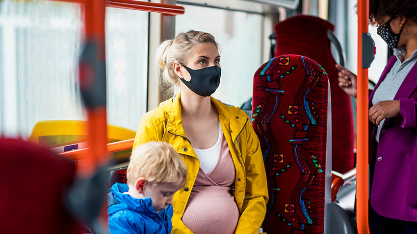 一名孕妇带着孩子在公交车上