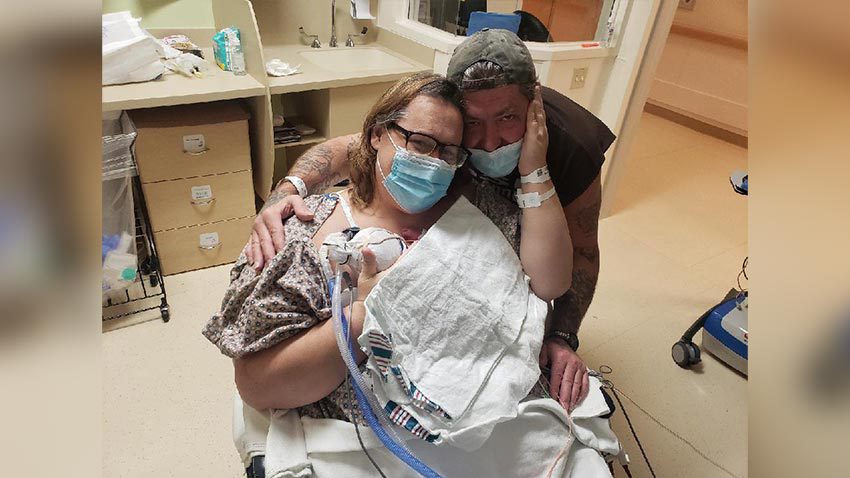 父母抱着婴儿在医院轮椅